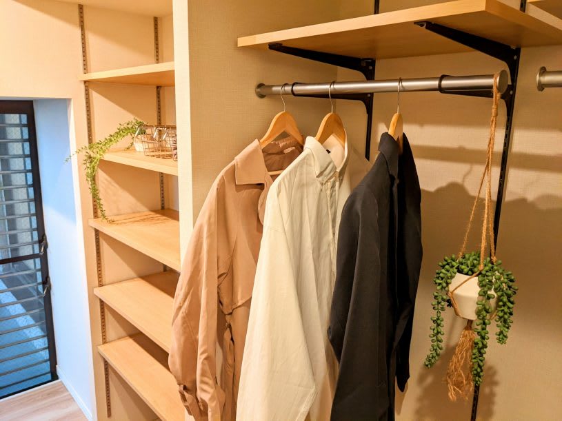 A minimalist closet with open shelves and hanging clothes