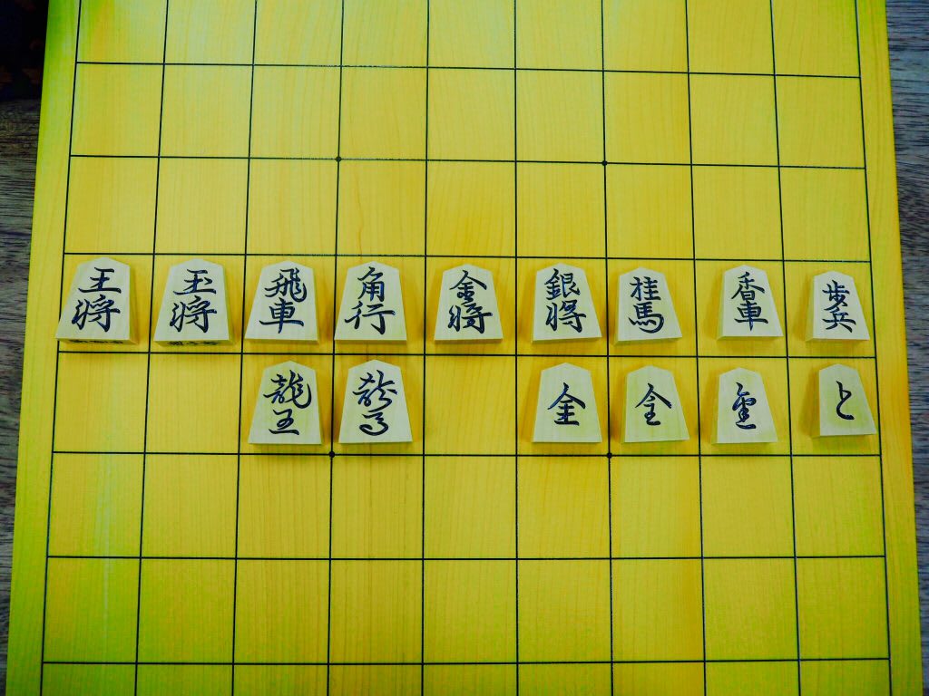 A shogi board displaying various shogi pieces with their corresponding kanji