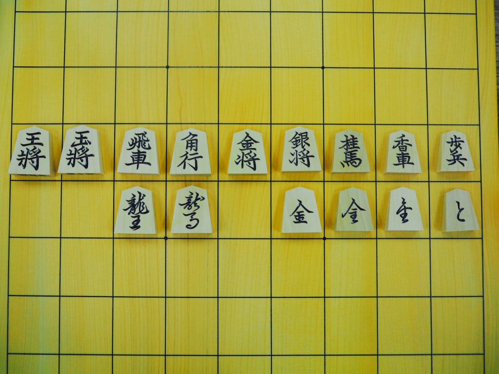 Different shogi pieces shown with different calligraphic styles